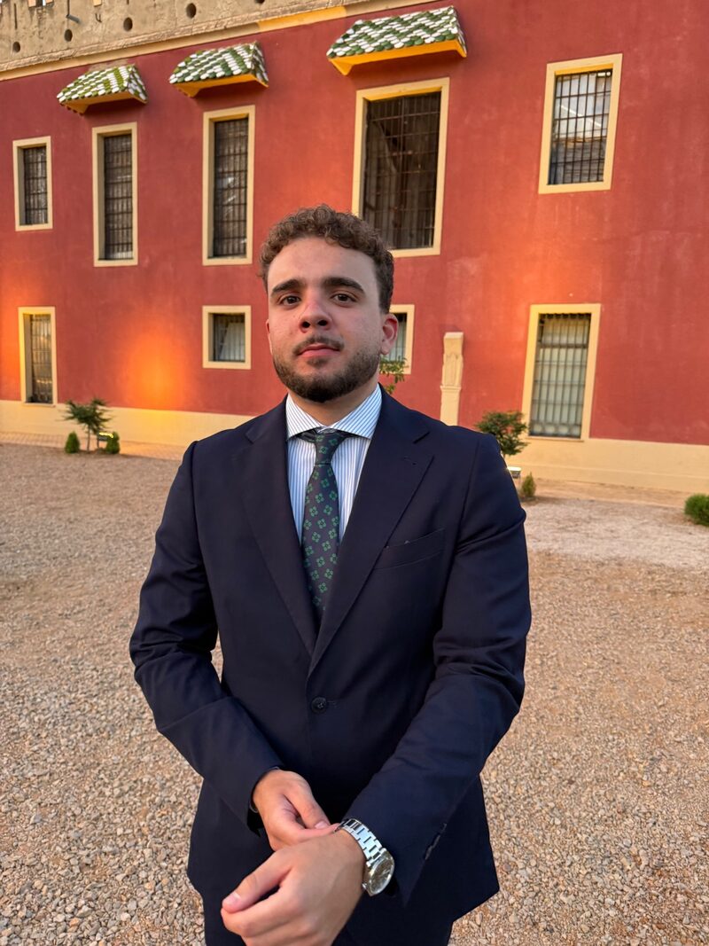 Carlos Martínez Parra con traje frente a un edificio histórico